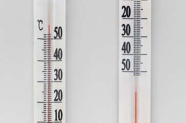 Two thermometers on a white background. Very hot or very cold.  Minimal concept.