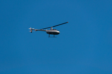 Helicopter flying against clear blue sky on the background