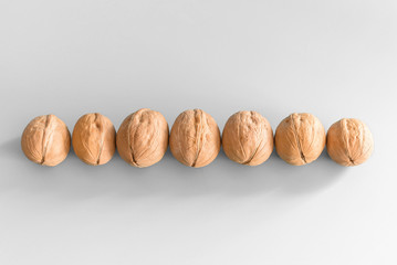 Seven walnuts in a row on a white background