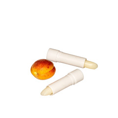 Hygienic lipstick based on apricot fruits on a white background with copy space.
