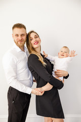 young beautiful family stylishly dressed standing in a bright apartment