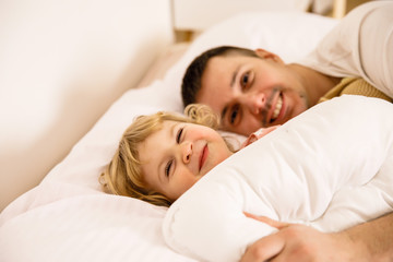 Fototapeta na wymiar little girl sleeping with her dad in bed
