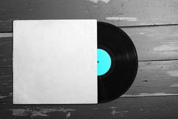 Vinyl record on old  wooden background. Copy space for your label