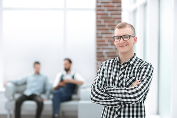 serious young man standing in spacious office