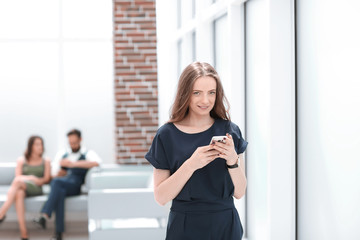 young woman uses her smartphone in the office