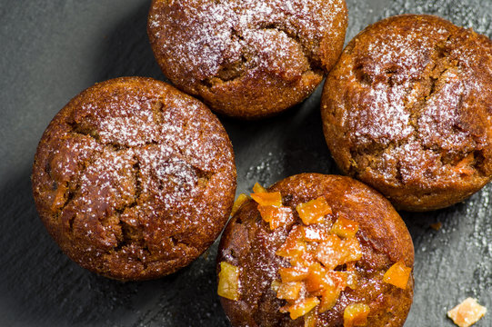 Widok z g&oacute;ry na muffinki. Jedna udekorowana sk&oacute;rką pomarańczową.