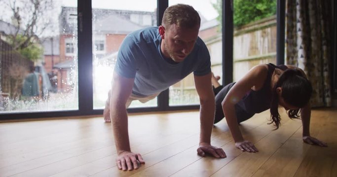 4K Fitness couple doing push ups together with girl failing to keep up the pace