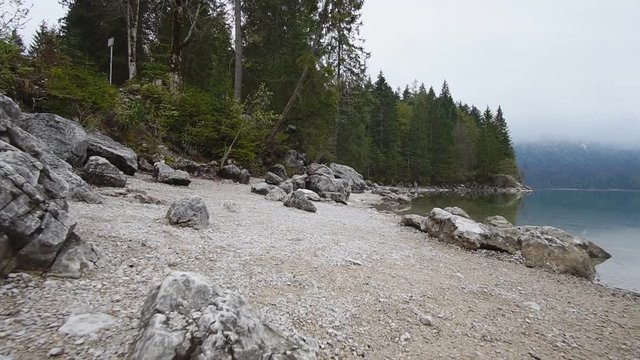 Steadycam shot of a rocky coast of lake in mountains, slow motion