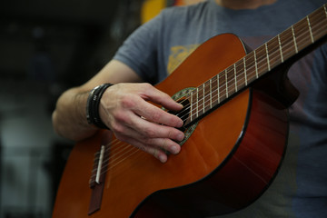 Man playing a classic guitar. Hand picks up the strings on the guitar.