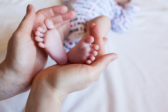 Children's feet in the hands of parents