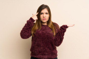 Young girl making the gesture of madness putting finger on the head