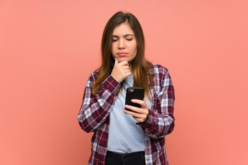 Young girl over pink wall thinking and sending a message