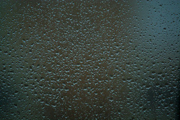 Background or texture. It is a lot of small a rain drops on window glass. Rainy day of spring.