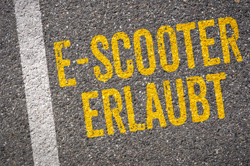 Asphalt mit dem Text E-Scooter erlaubt