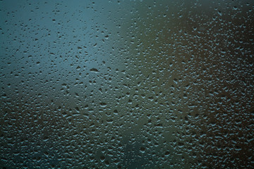 Background or texture. It is a lot of small a rain drops on window glass. Rainy day of spring.