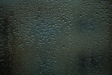 Background or texture. It is a lot of small a rain drops on window glass. Rainy day of spring.