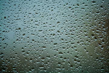 Background or texture. It is a lot of small a rain drops on window glass. Rainy day of spring.