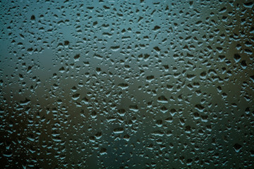 Background or texture. It is a lot of small a rain drops on window glass. Rainy day of spring.