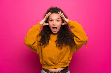 Teenager girl over pink wall with surprise expression