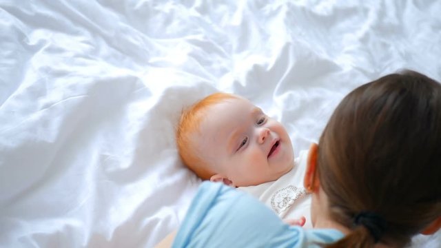 Mother and Baby. Happy Family. Mom With her readhead daughter smiling and laughing at home.
