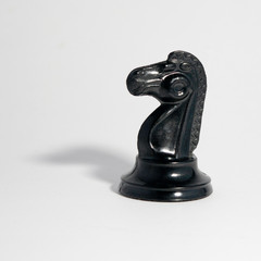 black chess knight on a white background, tight shadow © сергей тарануха