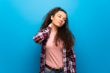 Teenager girl over blue wall with neckache