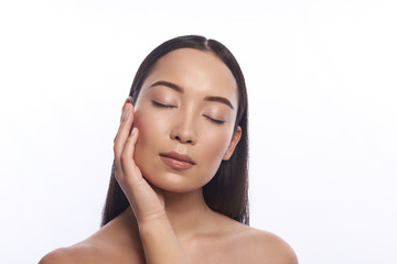 Woman standing with her eyes closed and putting one hand on the cheek