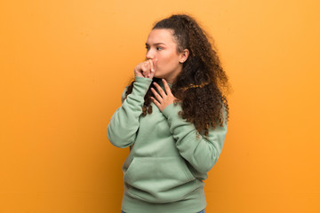 Teenager girl over ocher wall is suffering with cough and feeling bad
