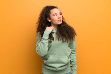 Teenager girl over ocher wall with tired and sick expression