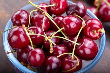cherry in glass plate with wooden background.