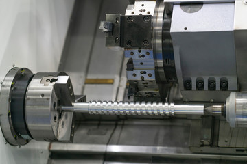 Operator machining automotive part by cnc turning machine,
