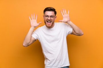 Fototapeta premium Redhead man over brown wall with glasses and smiling