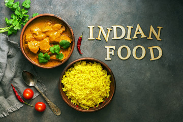 Indian food spicy chicken tikka masala with rice on a dark background. Tex from wooden letters-Indian food. Top view, flat lay.