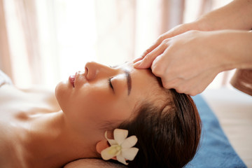 Obraz na płótnie Canvas Beautician massaging forehead of client