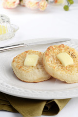 Obraz na płótnie Canvas english crumpets with melting butter and a knife