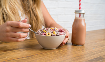 Young blonde woman with bowl of cereals