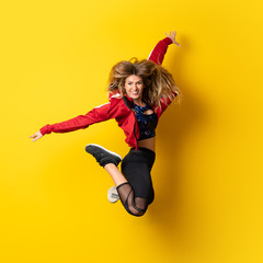 Urban Ballerina dancing over isolated yellow background and jumping