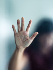 Blurry woman hand behind frosted glass metaphor panic and negative dark emotional