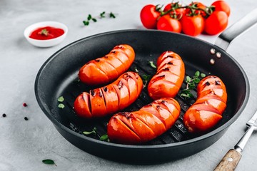 Grilled sausages in cast iron pan.