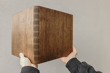 Man holds Photobook in a wooden cover. Guy holds notebook with plywood cover