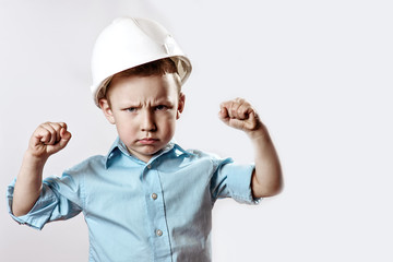 boy in a light shirt and helmet Builder shows how he is strong and confident