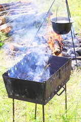 cooking delicious tasty food outdoors on fire in iron pot in summer in good weather with wood from...