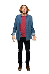 Fototapeta premium Full-length shot of Blonde man shouting to the front with mouth wide open over isolated white background