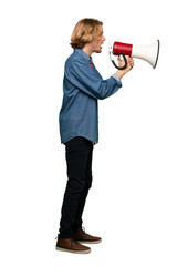 Full-length shot of Blonde man shouting through a megaphone over isolated white background