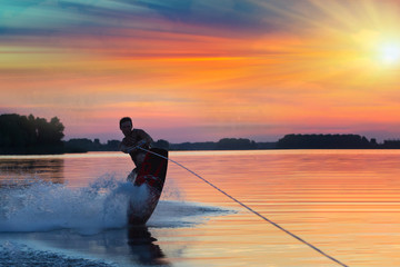 Wakeboarder does tricks on the wake. Beautiful summer background. Active holiday on vacation. The evil way of life. Water sports. Space for text