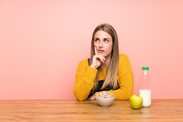 Young woman with bowl of cereals thinking an idea