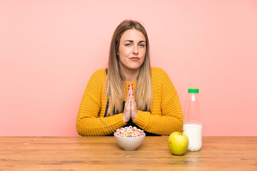Young woman with bowl of cereals pleading