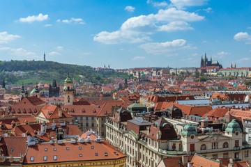 Obraz premium Outdoor sunny panoramic aerial scenery of rooftop in old town, city skyline, Charles Bridge tower and background range of mountain with Prague Castle and St. Vitus Cathedral in Prague, Czech Republic.