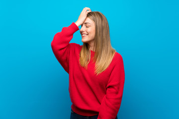 Woman with red sweater over blue wall has realized something and intending the solution