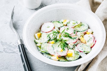 Fresh summer salad with cucumbers, radishes, eggs with cream fresh dressing